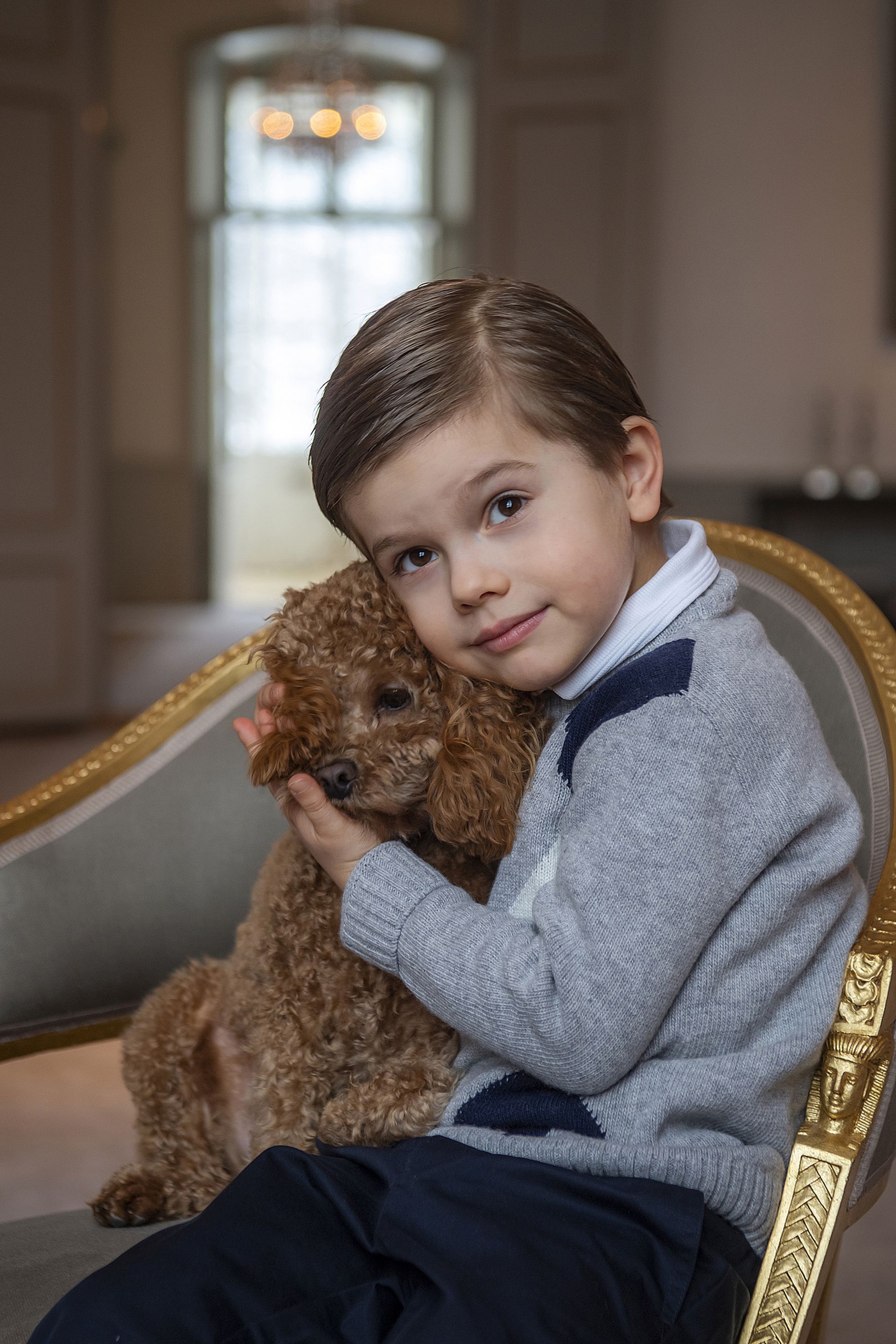 Voor zijn vijfde verjaardag gaat Oscar op de foto met hondje Rio.