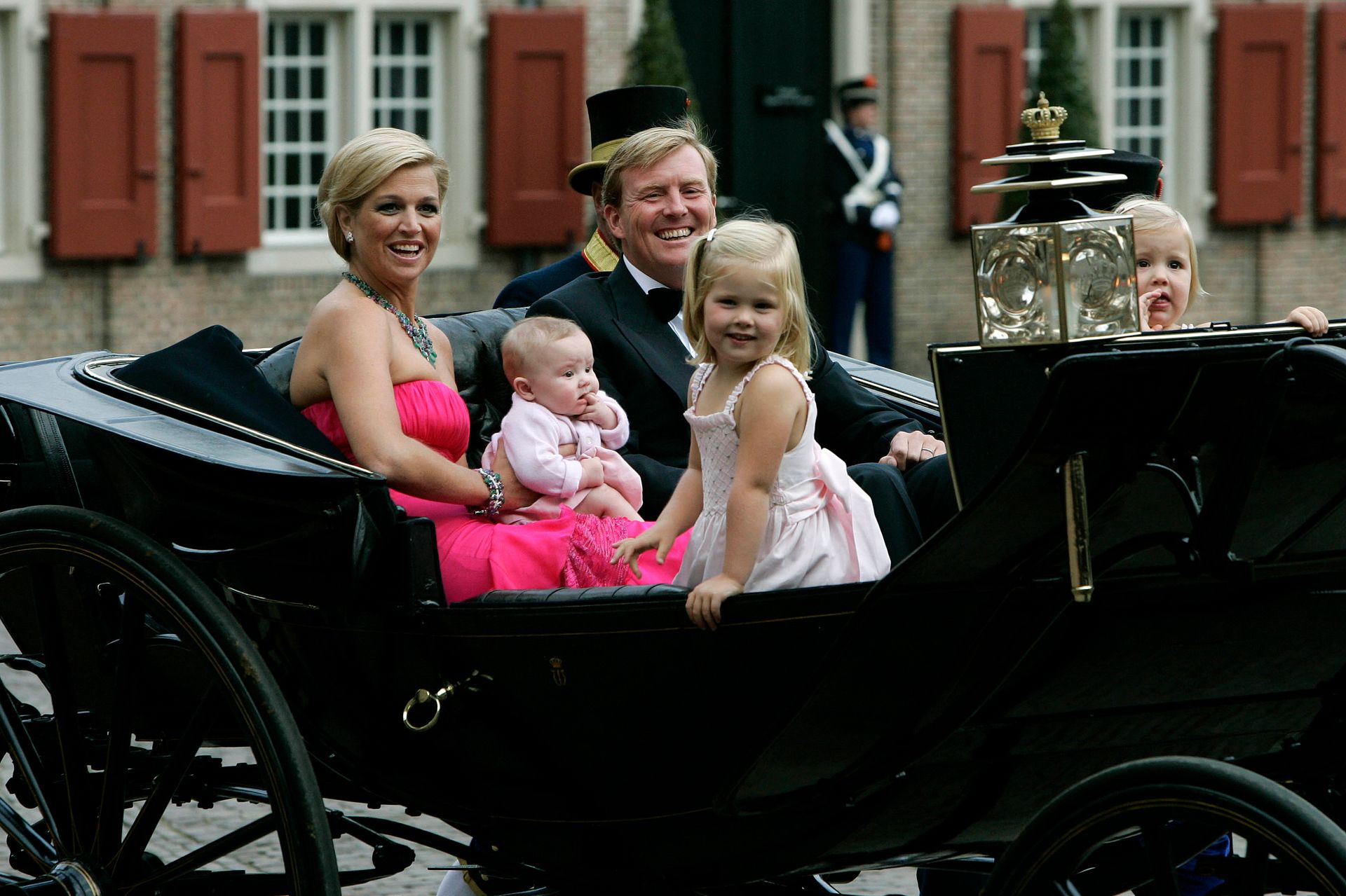 Willem-Alexander en zijn gezin arriveren per open koets bij Paleis Het Loo.
