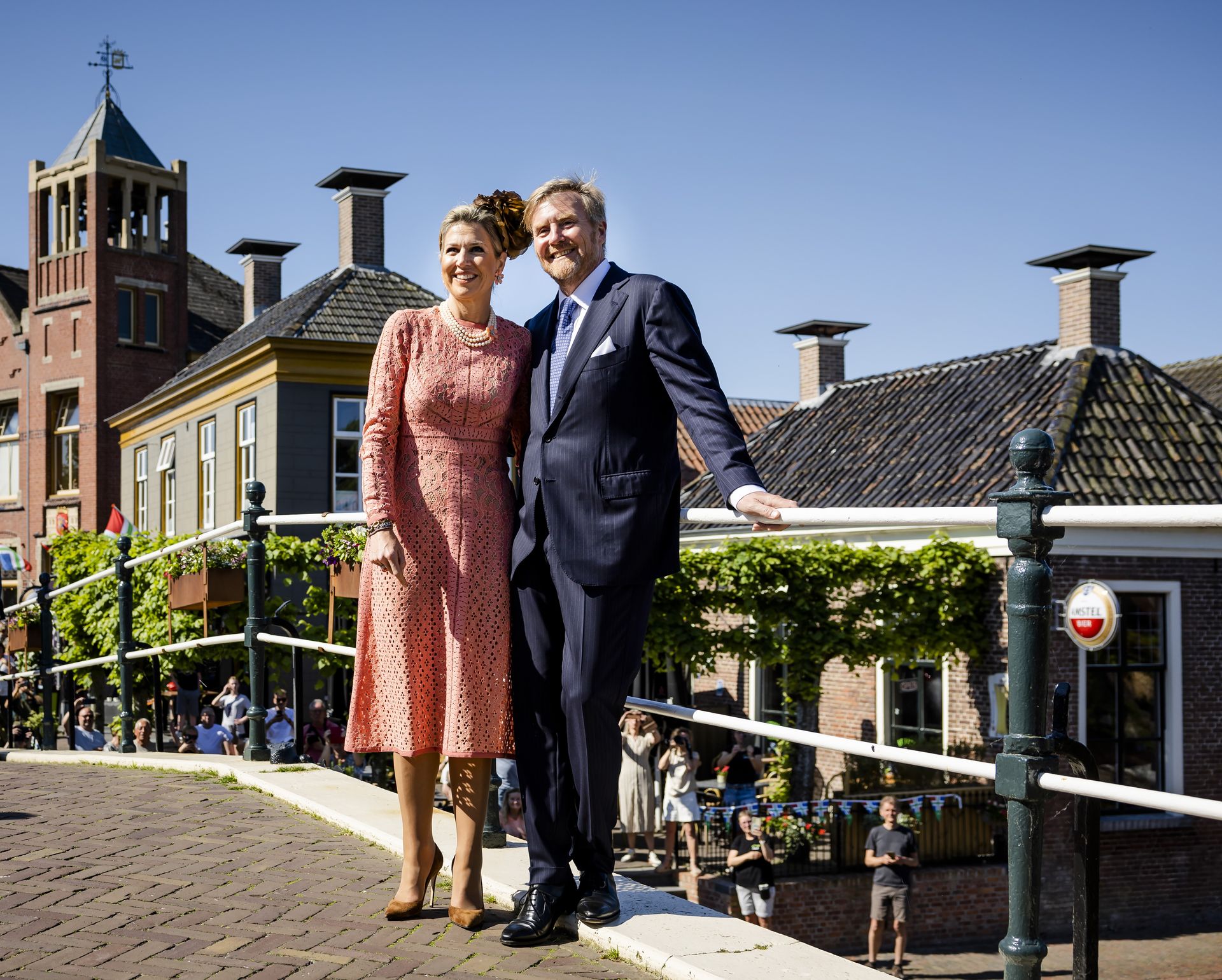 Koning Willem-Alexander en koningin Maxima poseren op brug De Boog bij het centrum van het dorp.