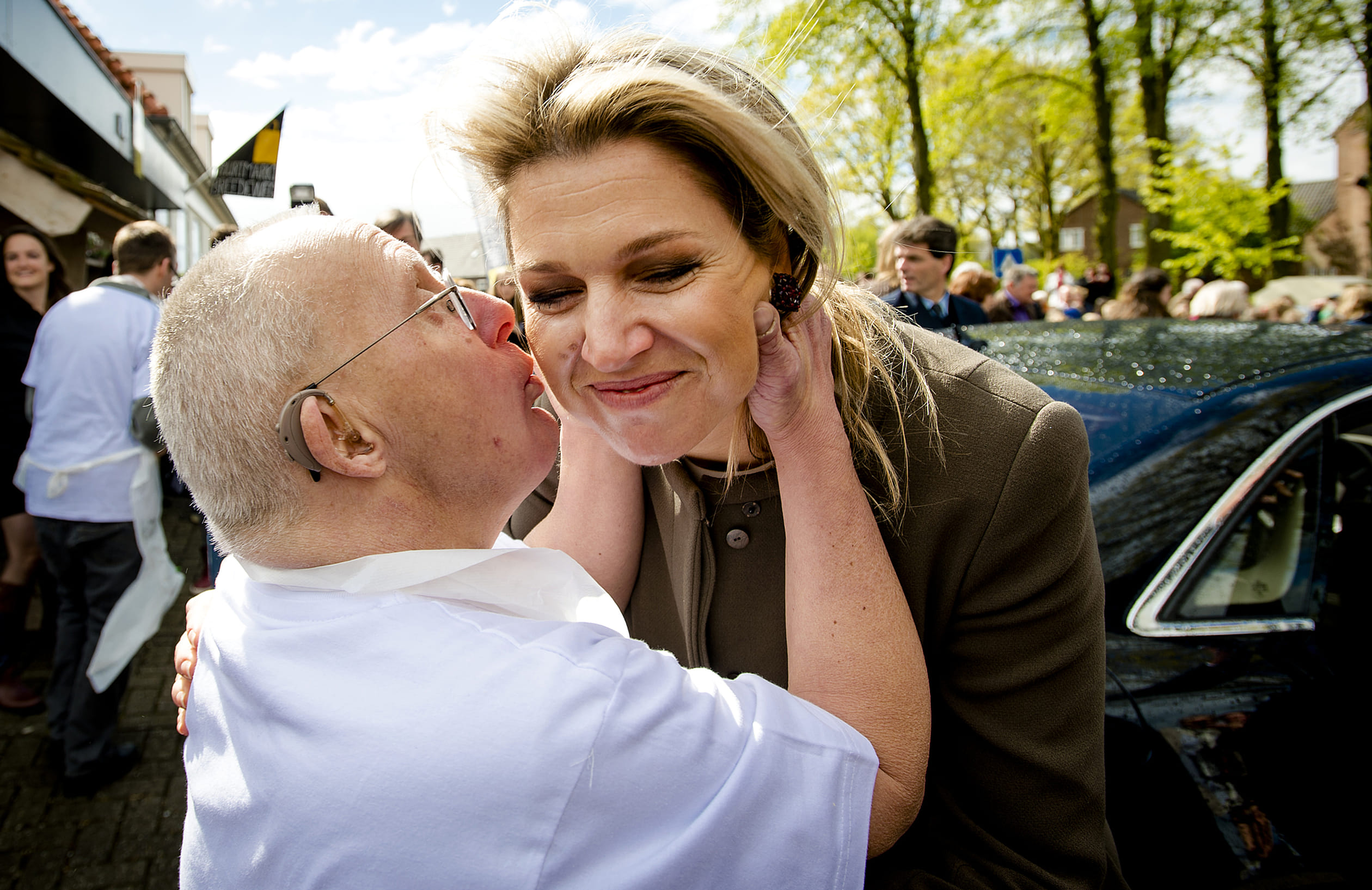 Maxima krijgt een zoen van medewerker Gerard aan het einde van haar bezoek aan Buurtmarkt Breedeweg,