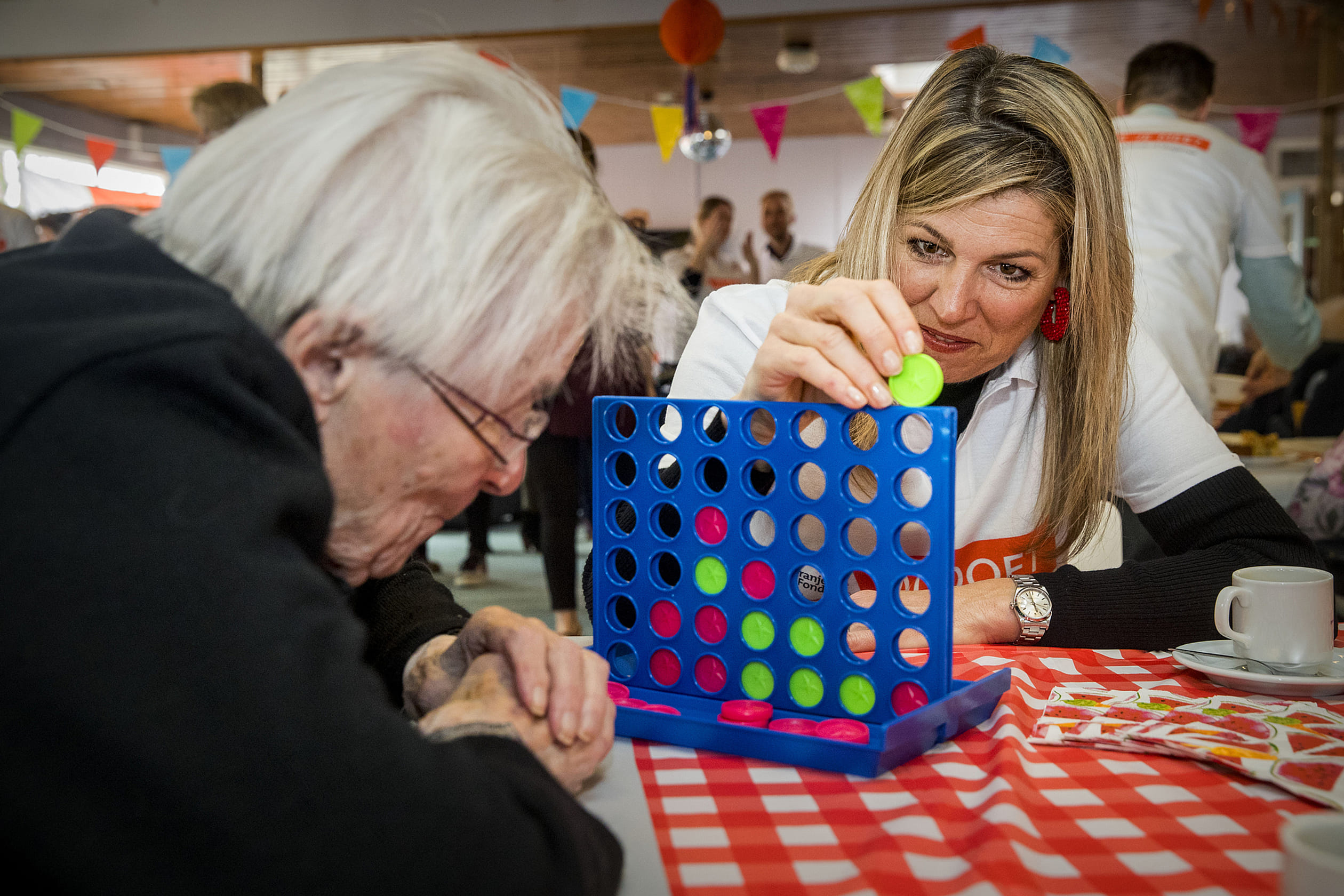 Wie wint vier op een rij? Koningin Máxima is wel te porren voor een spelletje met ouderen tijdens de