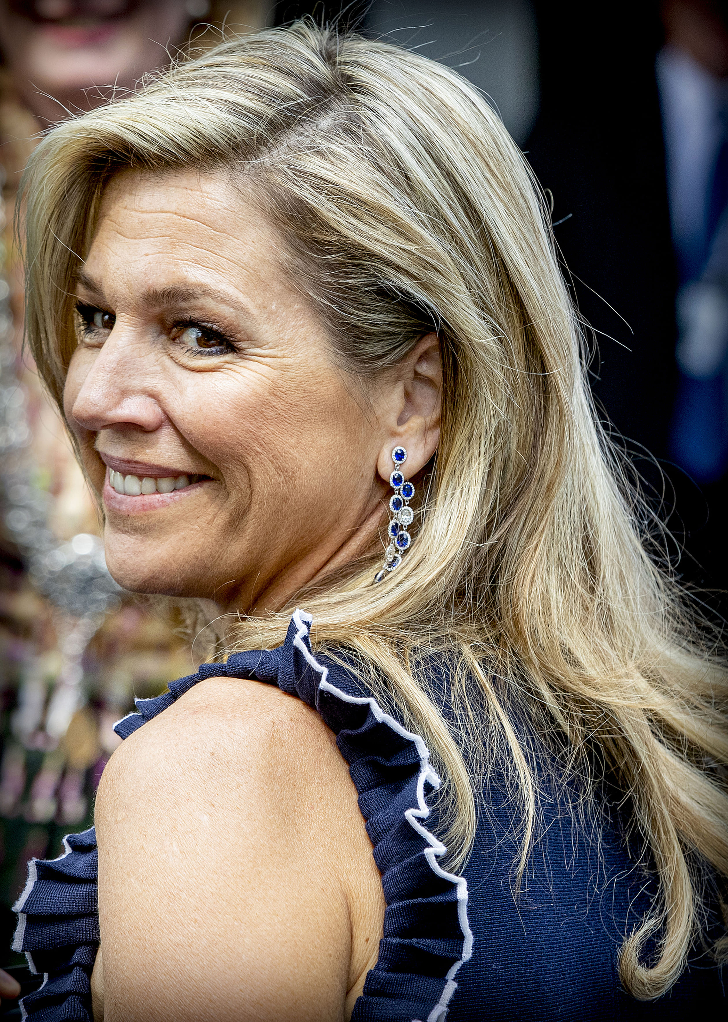 Koningin Máxima straalt in een cold-shoulderjurk met volants van het merk Oscar de la Renta.
