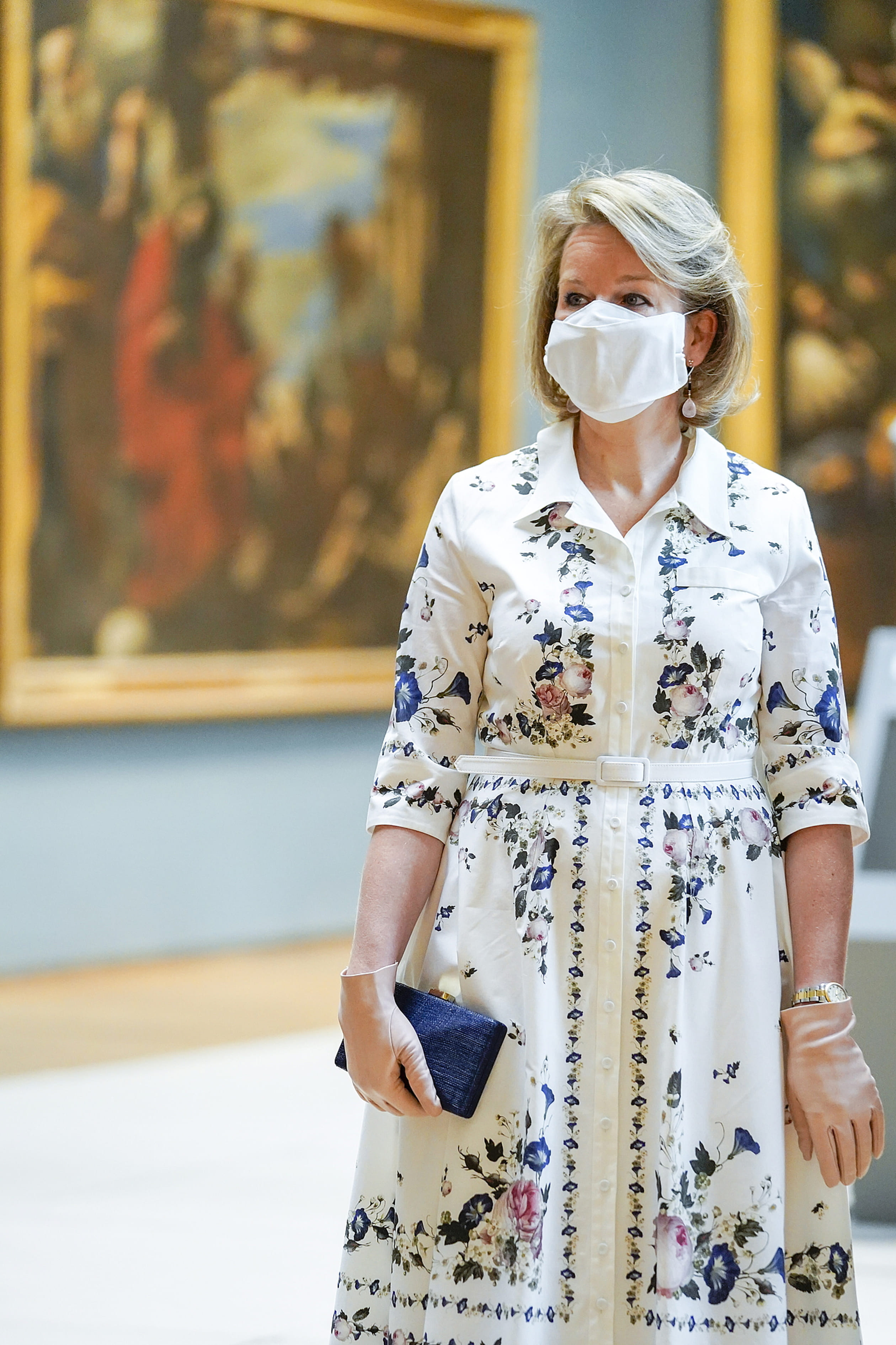 Koningin Mathilde draagt een witte hemdjurk met bloemenprint van het modelabel Erdem.