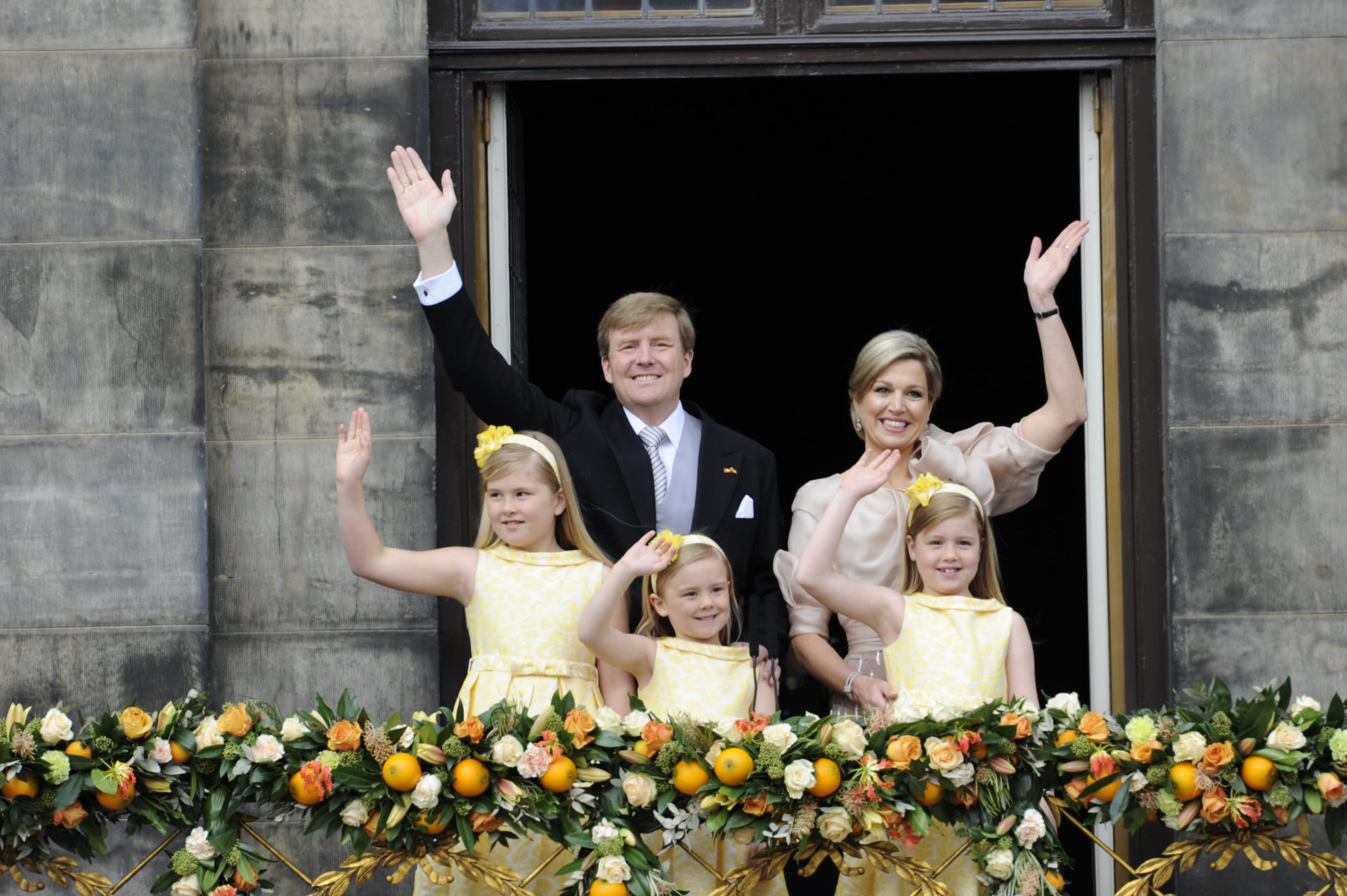 Kroonprinses Amalia en de prinsessen Alexia en Ariane staan met hun ouders, koning Willem-Alexander