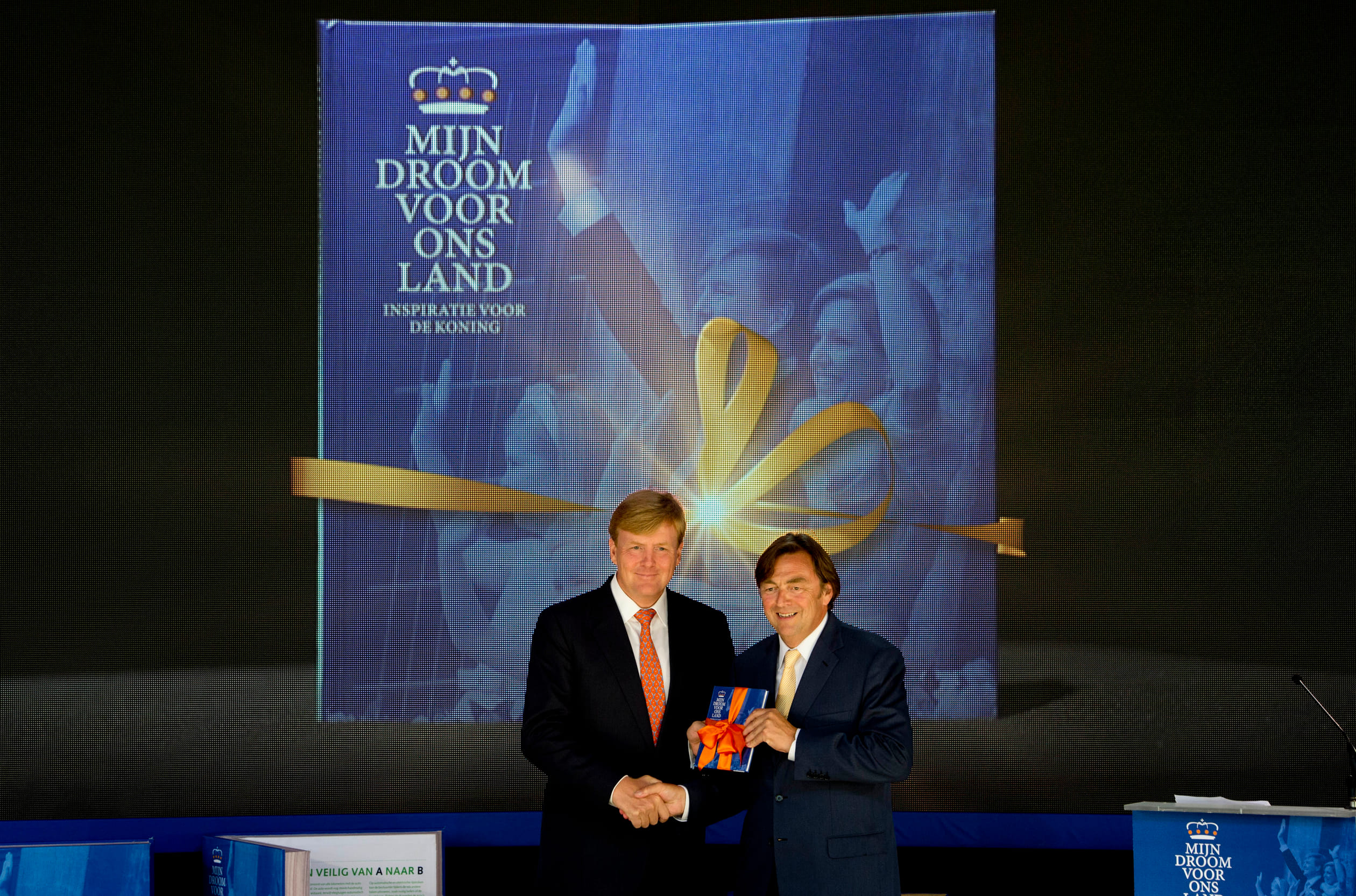 Willem-Alexander krijgt het eerste exemplaar van het droomboek overhandigd door Hans Weijers,