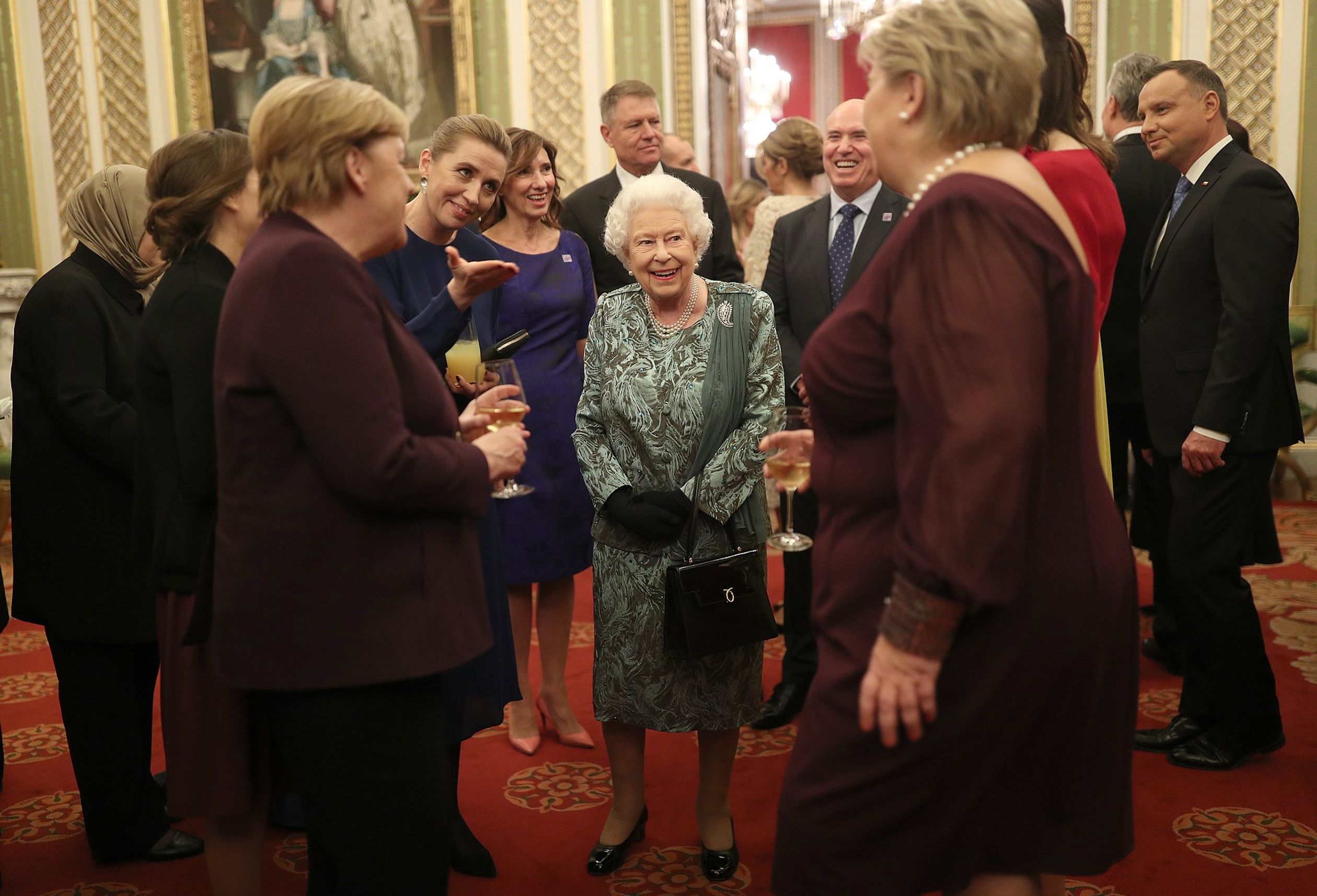 Koningin Elizabeth maakt een praatje met onder andere de Duitse bondskanselier Angela Merkel.