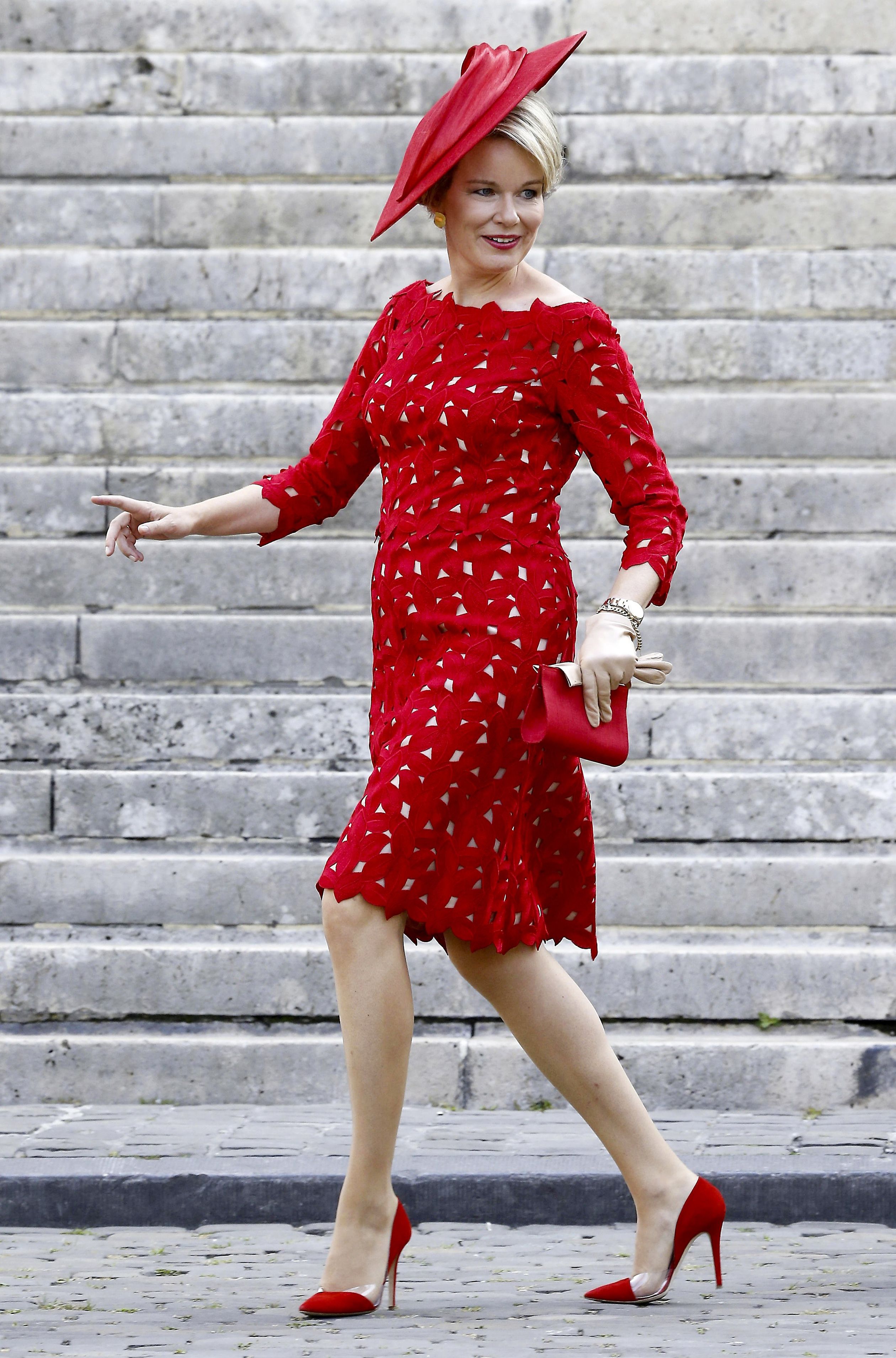 De felrode jurk is van de hand van Edouard Vermeulen van het Belgische modehuis Natan. De hoed is