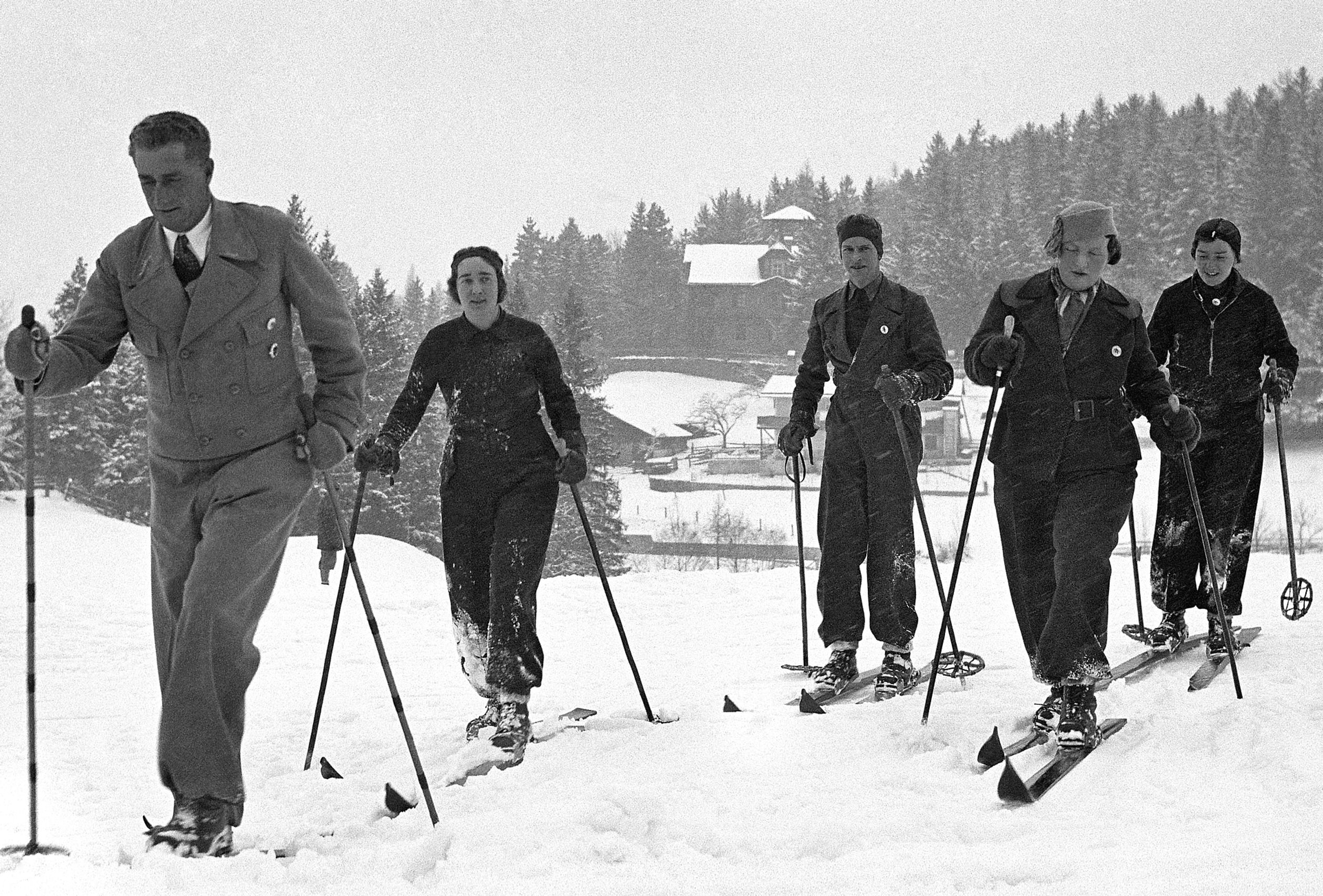 Prinses Juliana op ski's, omringd door hofdames en de ski-leraar (links) in Igls.
