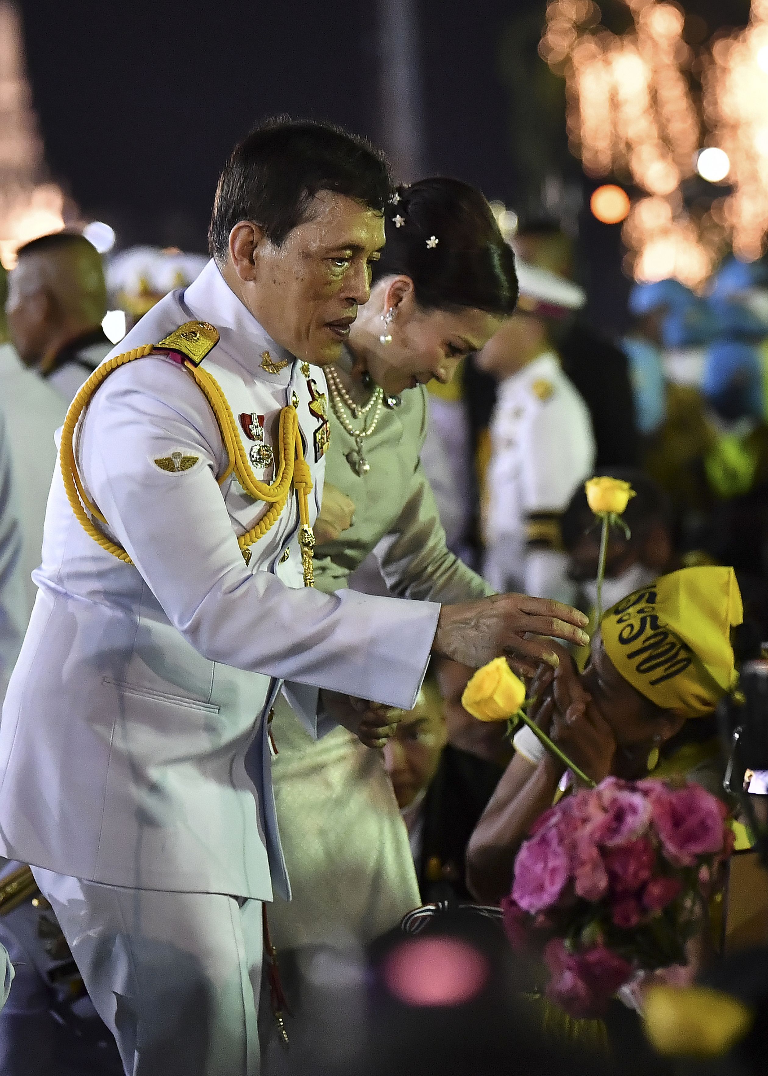Koning Maha Vajiralongkorn en koningin Suthida begroeting koningshuis supporters buiten bij het