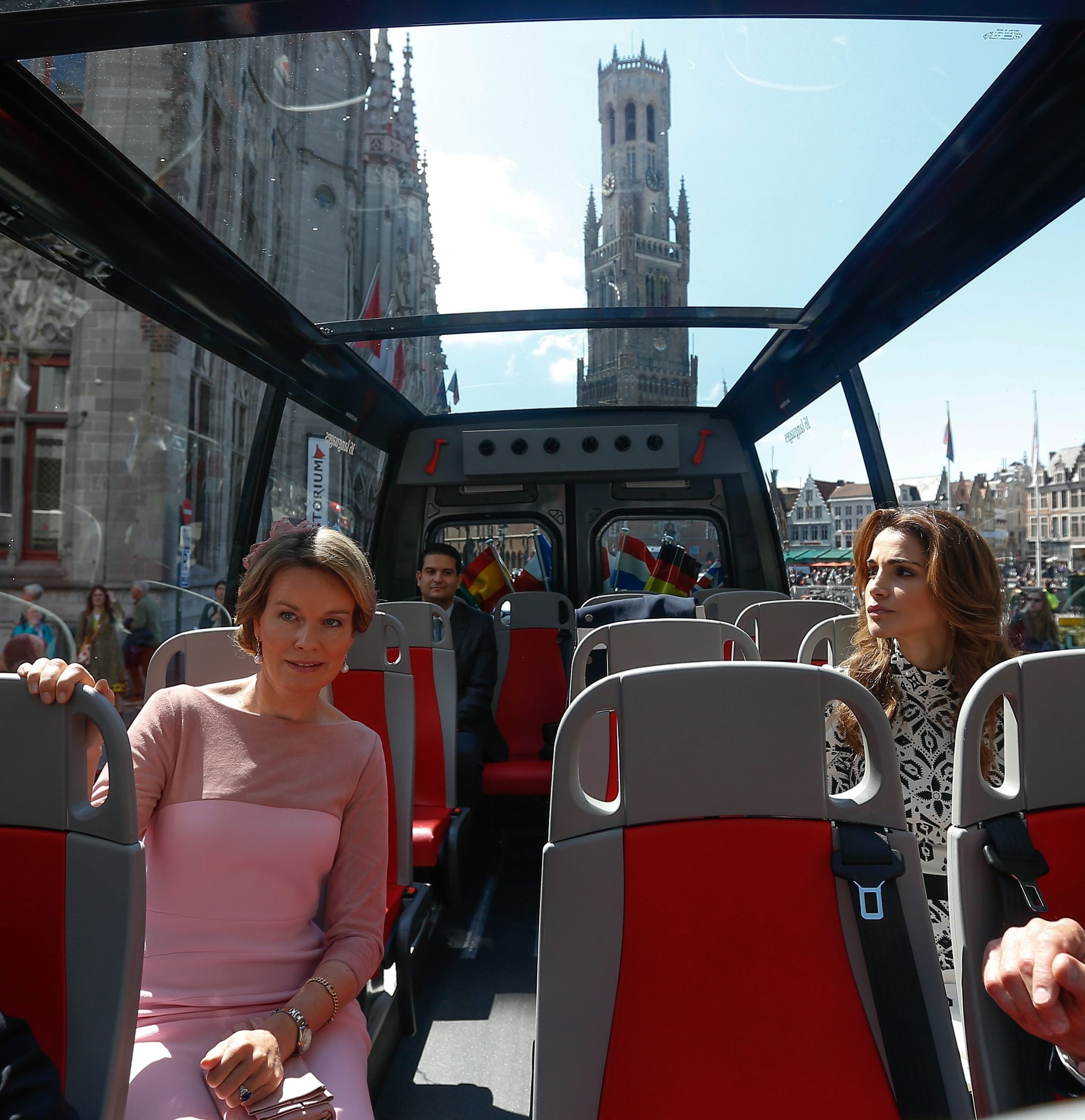 2016: Koningin Mathilde neemt koningin Rania mee in een tourbus door Brugge.