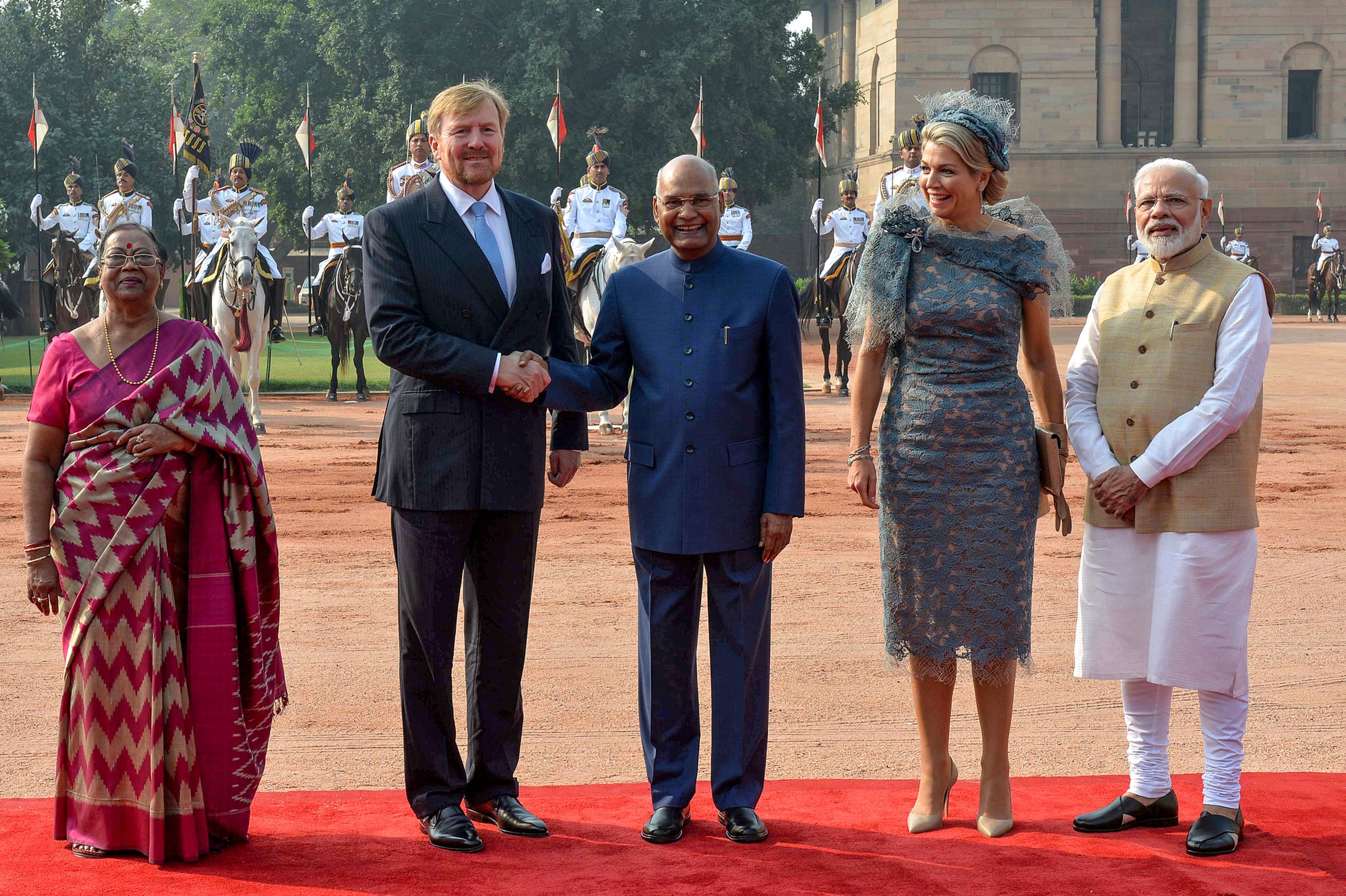 Koning Willem-Alexander schudt de hand van president Ram Nath Kovind. Links staat de echtgenote van