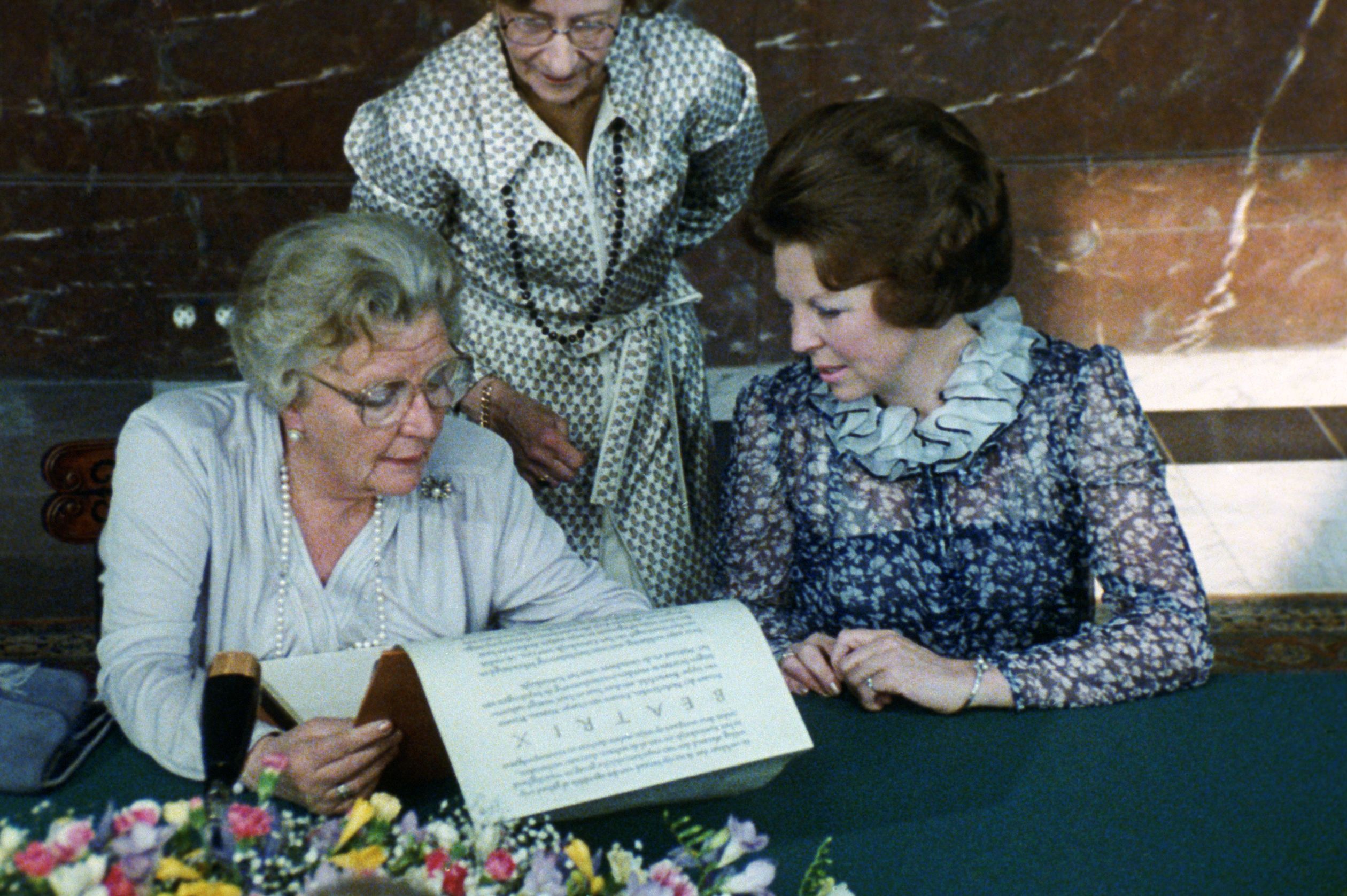 Juliana en Beatrix ondertekenen de akte van abdicatie.