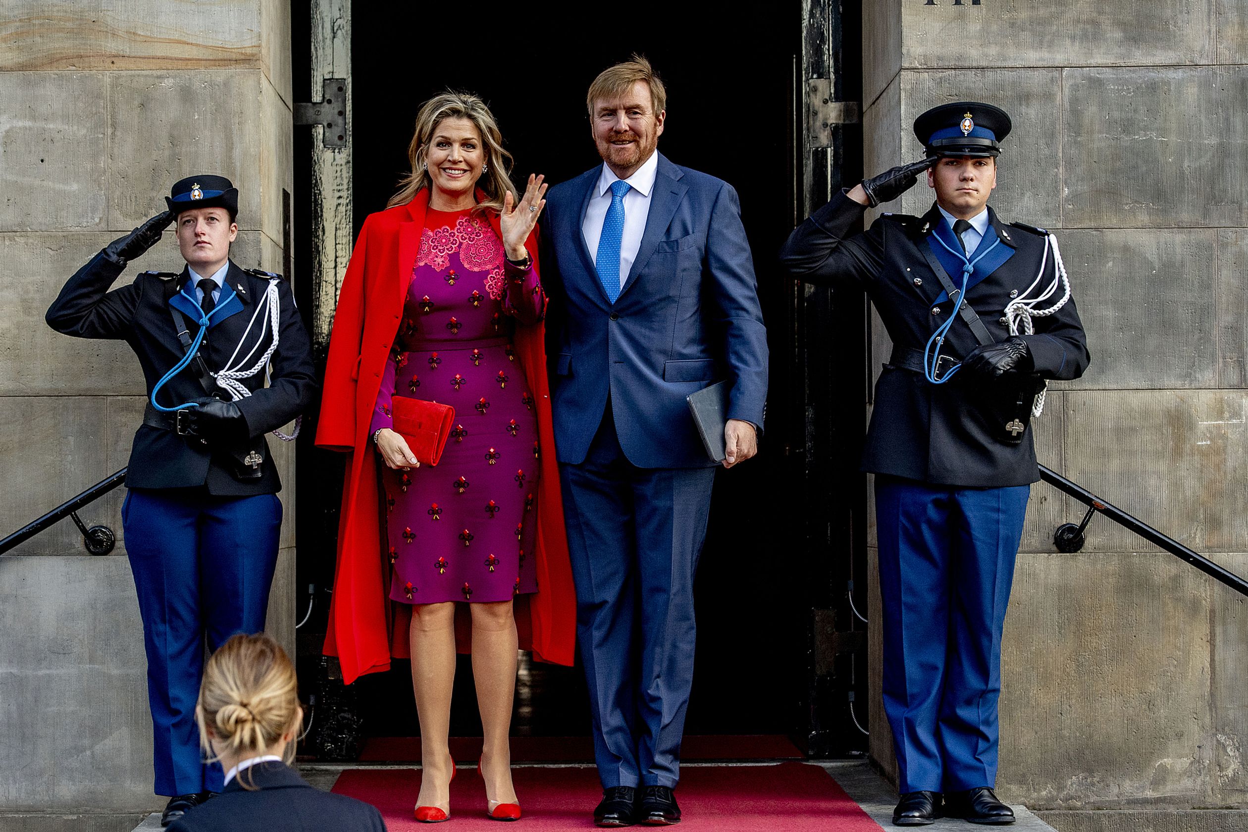 Máxima draagt een paarse jurk met een felrode jas bij de uitreiking van de Grote Prins Claus Prijs
