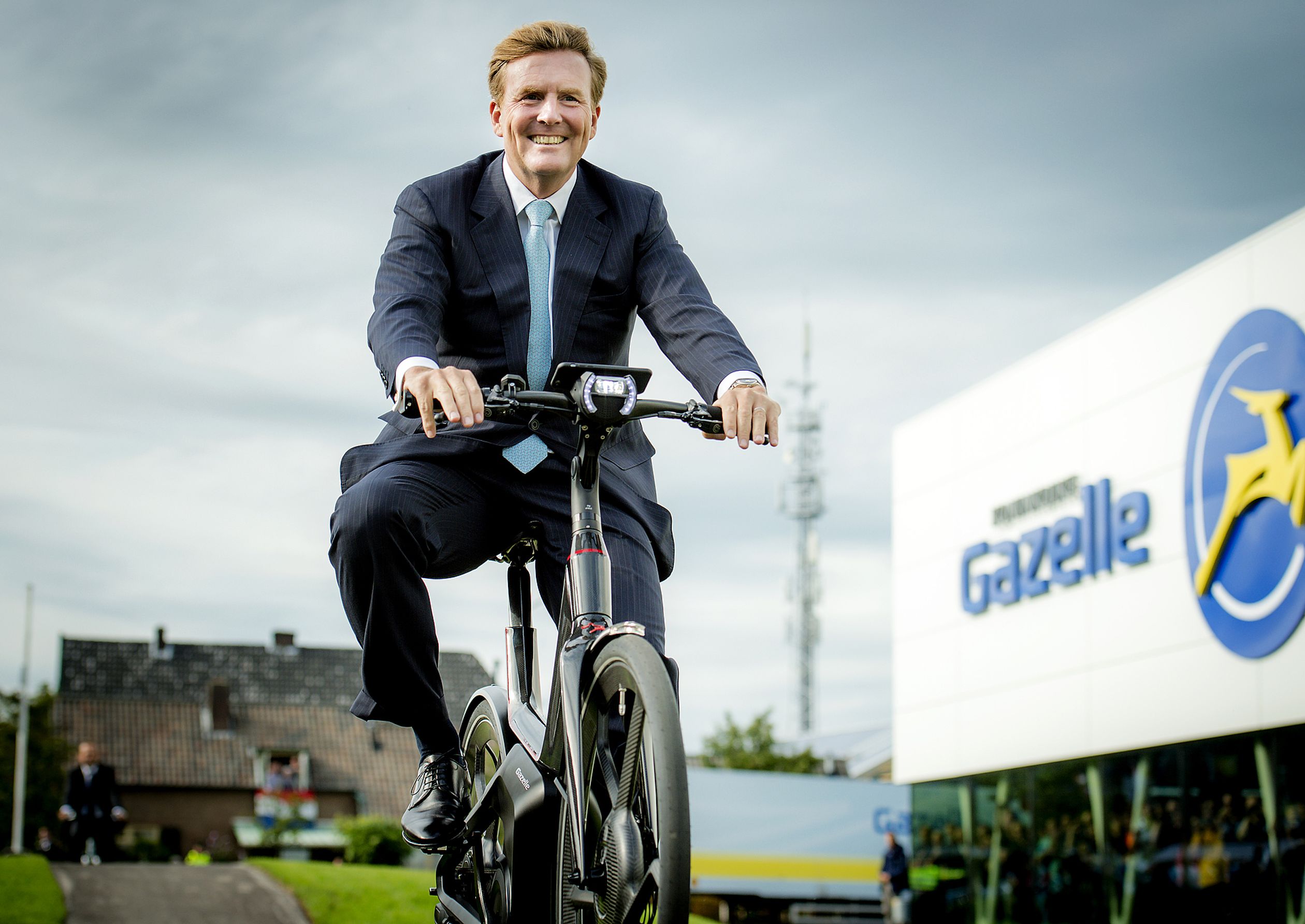 Koning Willem-Alexander op de fiets tijdens de opening van een nieuwe fietsfabriek in 2015.