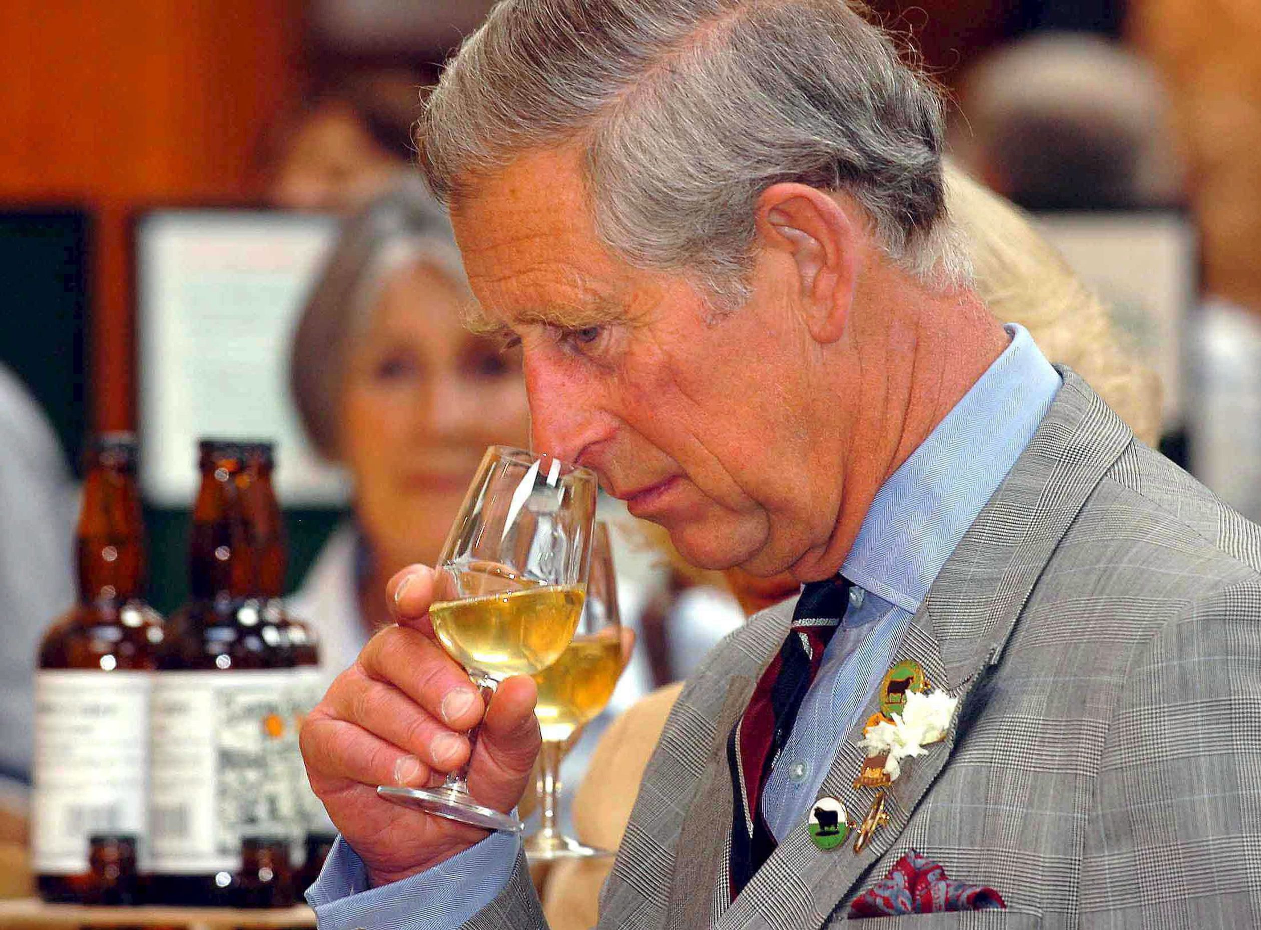 Charles ruikt aan zijn glas wijn tijdens een bezoek aan Three Counties Agricultural Show in