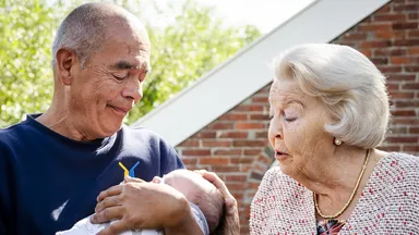 Prinses Beatrix knuffelt met baby tijdens heropening van molen