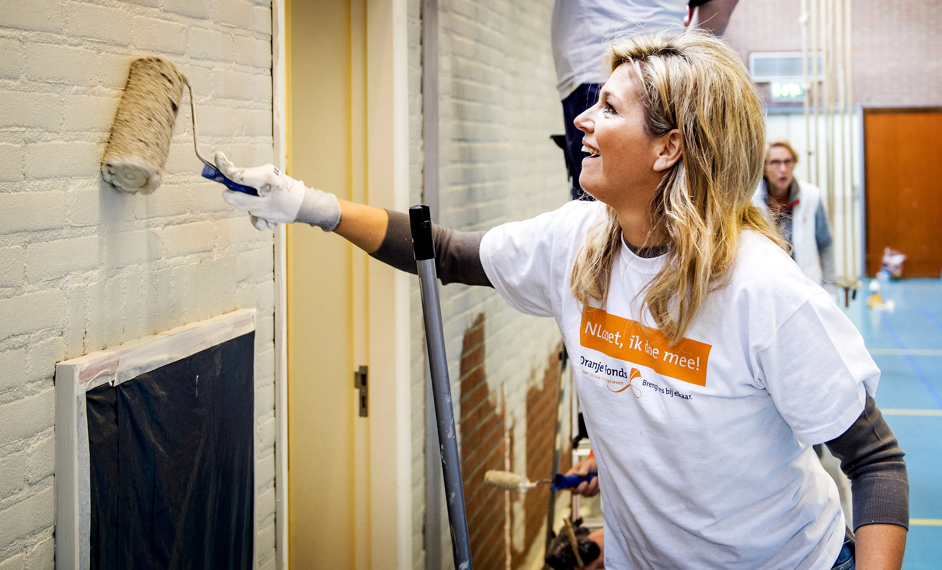 Máxima helpt bij het witten van een sportruimte (2015).