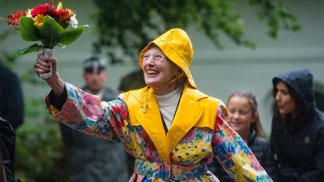 Koningin Margrethe in een regenjas.