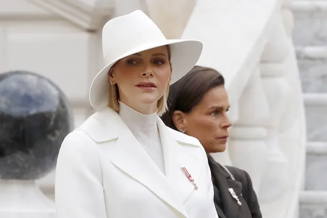 In 2019 gaat ze voor een volledige witte outfit: een pantalon met lange mantel. Naast Charlène staat haar schoonzus prinses Stéphanie.